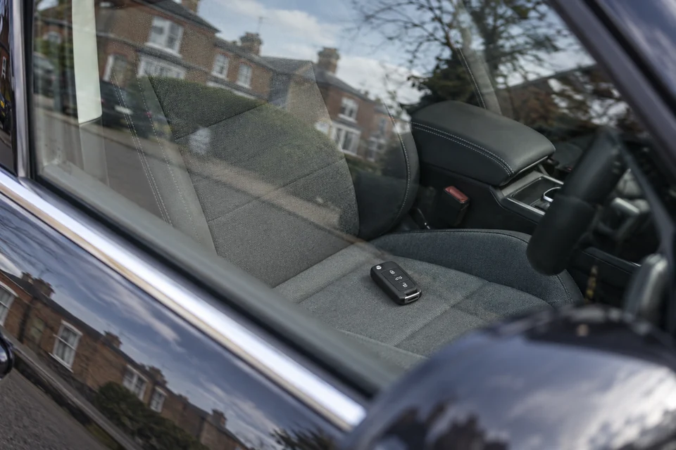 Car keys visible on the seat through a closed car window
